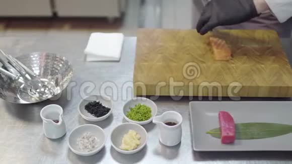 白餐厅厨师手里统一切小三文鱼厨房用具香料墨西哥菜酱汁视频的预览图