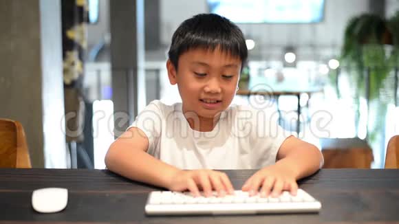 亚洲男孩在电脑上工作按下按键移动鼠标视频的预览图