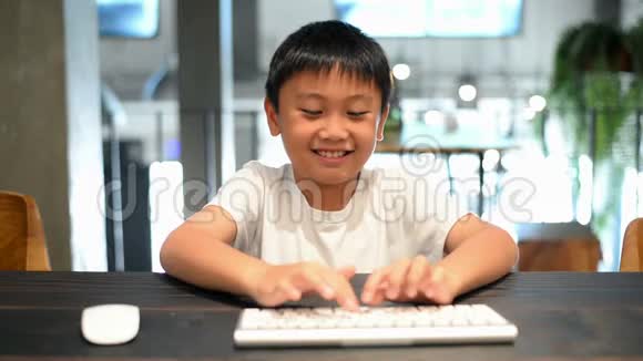 亚洲男孩学习电脑按下按键移动鼠标视频的预览图