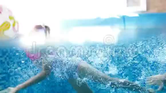 两个十几岁的女孩在室内游泳池水下潜水的4k视频儿童享受水的乐趣视频的预览图