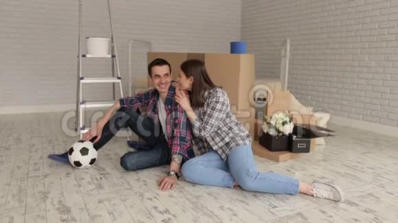 幸福的年轻夫妇坐在新公寓里的纸板箱里视频的预览图
