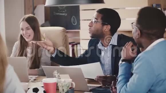 快乐的非裔美国公司老板领导创意讨论在多民族会议在阁楼办公室慢动作视频的预览图