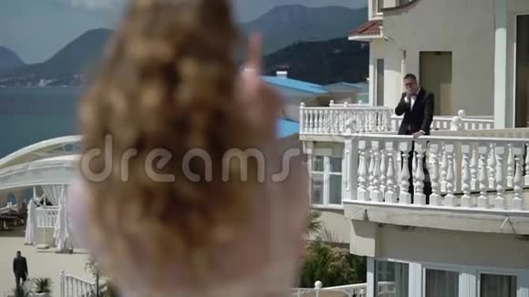男人和女人住在不同的阳台上送空气亲吻视频的预览图