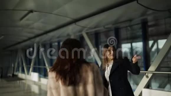 一个男人和两个女人沿着走廊走到前台一边笑着一边说话视频的预览图