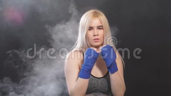 穿着拳击绷带摆姿势的漂亮金发女拳击手的肖像视频的预览图