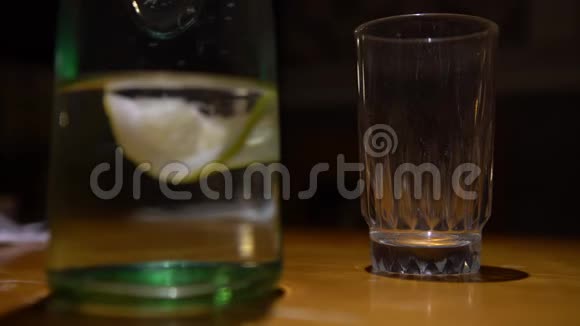 4K服务员用木桌在餐厅端上一杯水和柠檬视频的预览图
