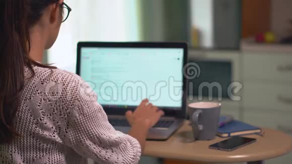 女孩坐在厨房自由职业者在家工作在笔记本电脑上搜索信息视频的预览图