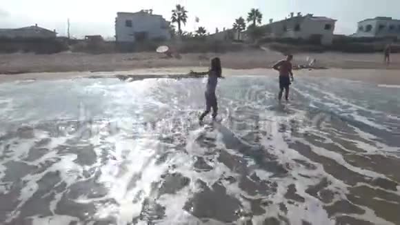 一名残疾青年在一次艰难的手术后与他的妹妹沿着沙滩沿着海岸奔跑视频的预览图