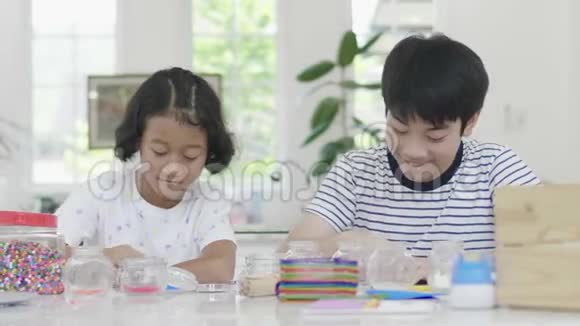 这位年轻的亚洲男孩和女孩正在用笑脸玩拼图游戏视频的预览图