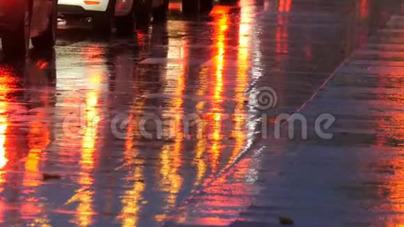 汽车在交通前灯在雨中的沥青视图下面晚上雨打水坑汽车灯光的反射视频的预览图