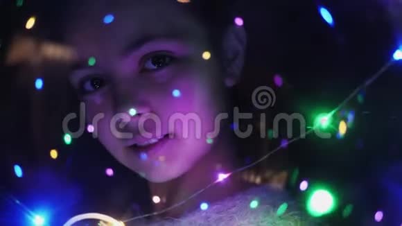 一个女孩通过发光的灯光特写视频的预览图