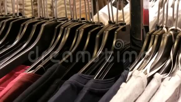 许多不同颜色妇女的衣服挂在衣架上躺在一家服装店的货架上视频的预览图
