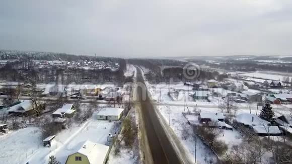 乡村十字路口空中景观靠近河流的村庄冬天和下雪视频的预览图