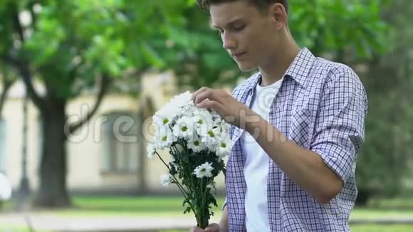 男孩捧着花等女朋友约会紧张没有安全感的少年视频的预览图
