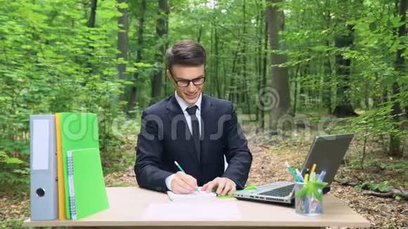 灵感来自商人他把自己的想法写在笔记本上坐在森林的办公桌前视频的预览图