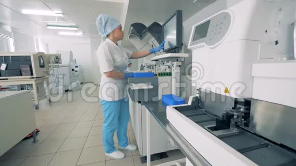 专家站在生化分析仪附近并与自动制药设备合作视频的预览图