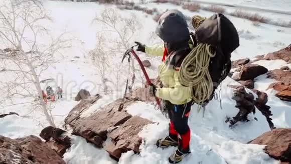 两个登山者爬上雪山的一个又大又陡的斜坡拉着绳子往上爬视频的预览图