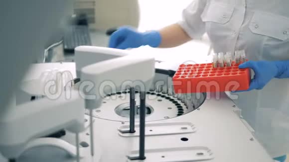 实验室工作人员将试管插入生化分析仪视频的预览图