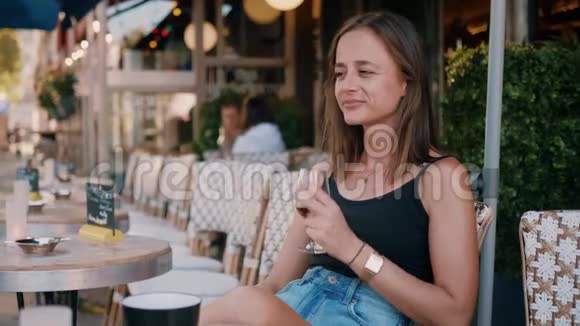 法国女孩在巴黎的街头咖啡馆喝一杯酒视频的预览图