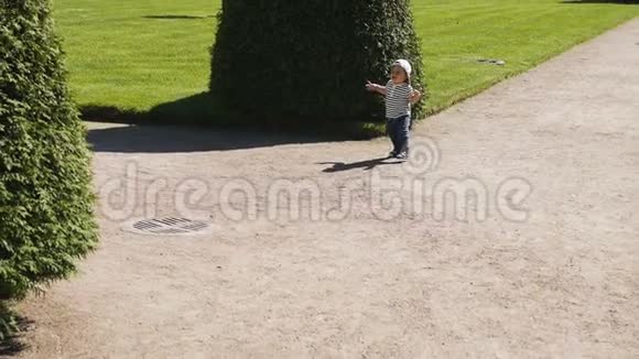 穿着帽子和t恤的小男孩在街上奔跑视频的预览图