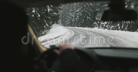4K超高清雪山公路上一个男子在汽车车轮前转弯视频的预览图