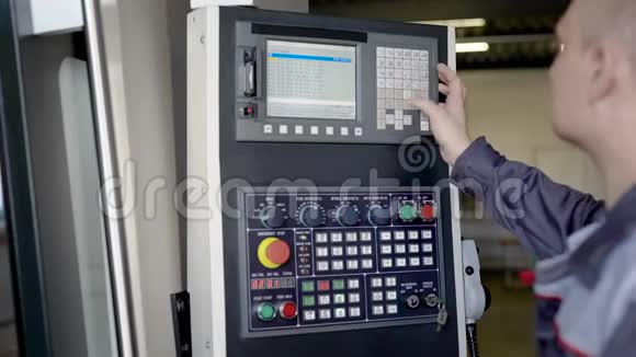 工程师正在生产车间编程数控机床按下按钮在屏幕上观看视频的预览图