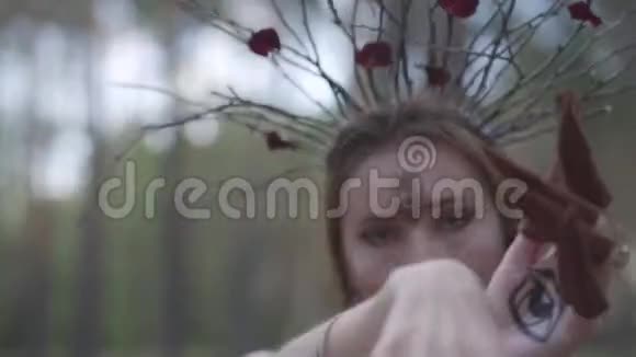 一个有吸引力的旱地或森林仙女的肖像头上戴着一个树枝花环第三只眼睛涂在上面视频的预览图