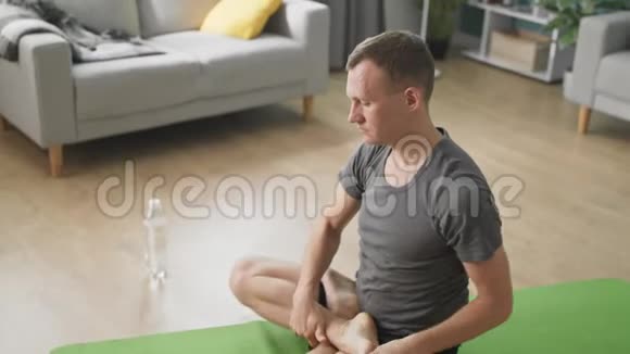 男子在家中进行个人训练放松肌肉和照顾健康视频的预览图