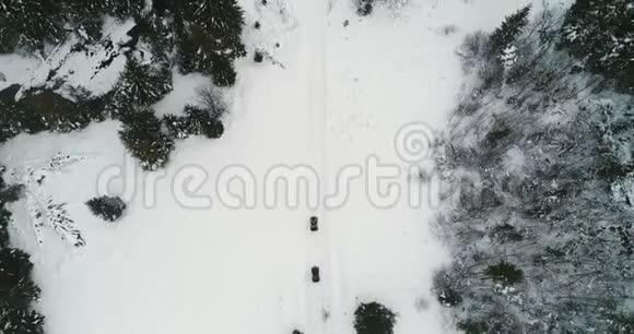 无人驾驶飞机飞越四辆自行车穿过白雪覆盖的4K超高清山脉视频的预览图