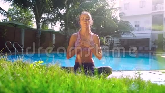 瑜伽姿势的女孩放松双手放在泳池的胸部视频的预览图