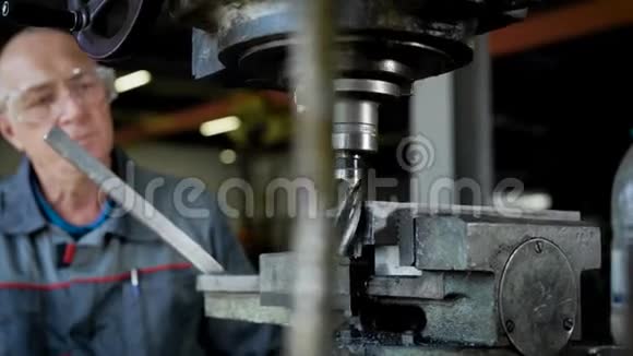 成熟的技工正在工厂的车间里控制着一台工业钻床视频的预览图