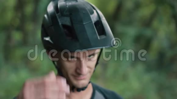 骑自行车的人用手敲他头上的头盔视频的预览图