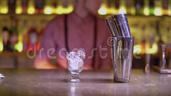 装有冰块和金属震动器的玻璃在酒吧柜台上酒保清洗背景玻璃视频的预览图