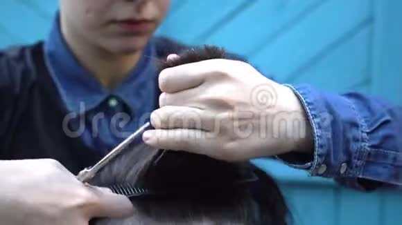 夏季在户外理发店年轻的女理发师慢慢地梳理和理发视频的预览图