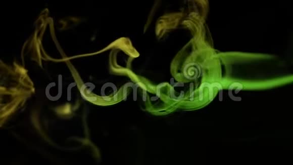 黄色和绿色的烟雾在黑色的背景上抽象的云抽象绿色照明视频的预览图