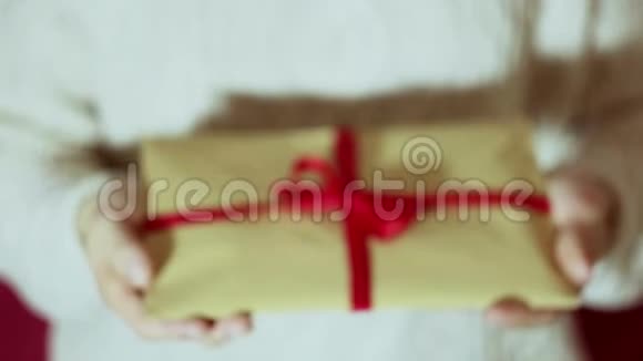 漂亮的女孩手里拿着一个带有红色丝带的礼物信封视频的预览图