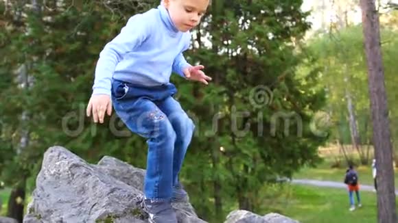 孩子在秋园好玩的玩耍嬉笑走在清新的空气中他喜欢爬大石头视频的预览图