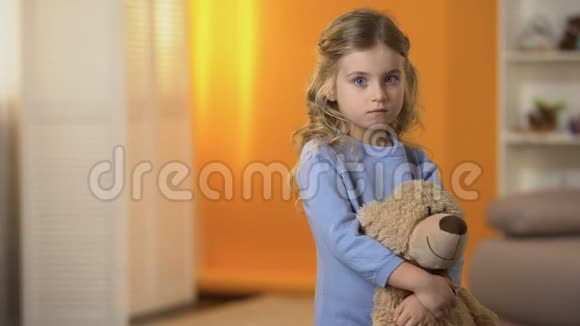 可爱的悲伤的小女孩拥抱最喜欢的泰迪熊感到孤独孤儿院视频的预览图