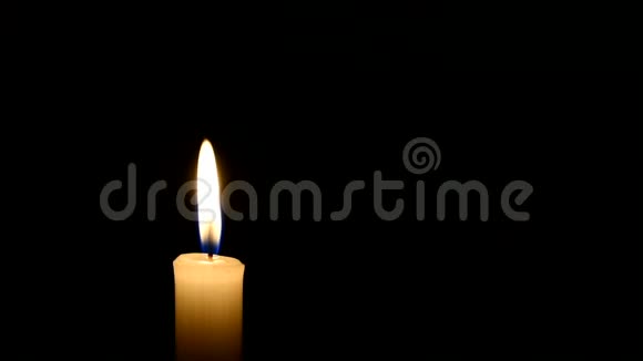 黑色背景上的蜡烛火焰黑暗中的老黄烛风在烛焰上吹视频的预览图