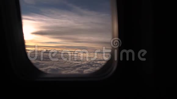 云层和阳光穿过飞机的舷窗视频的预览图