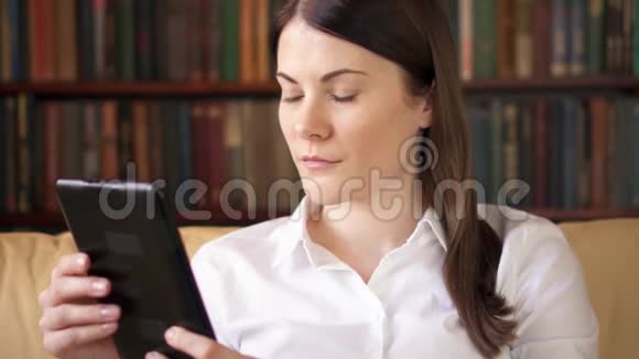 女人在家看电子书纸张与数字阅读电子书取代实体印刷书籍视频的预览图