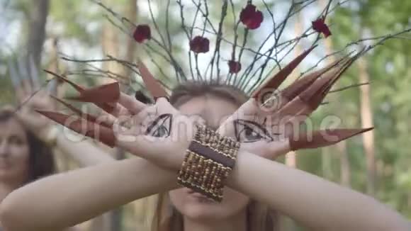 双手的干或森林仙女画着眼睛在手掌和假爪子跳舞和覆盖脸古代仪式视频的预览图