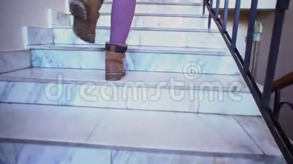 一个穿棕色鞋子的年轻女子爬上大理石楼梯视频的预览图