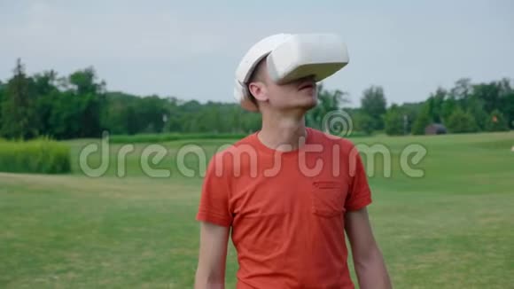 一个男人在公园里用一个虚拟现实耳机把头仰起来视频的预览图