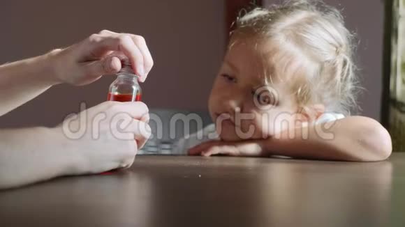 母亲给生病的孩子倒药糖浆视频的预览图