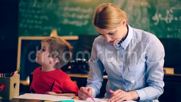老师在学校班上和一个小男孩订婚了穿制服的学童教室里的老师教师和视频的预览图