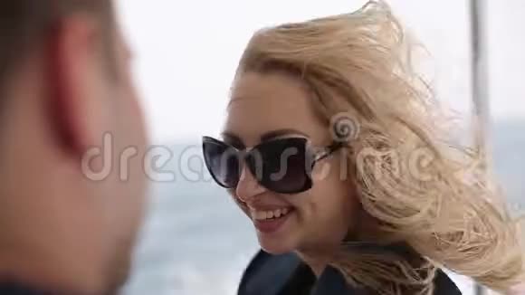 年轻女子坐快艇头发随风飘动成年夫妇在游艇甲板上享受暑假欧洲视频的预览图