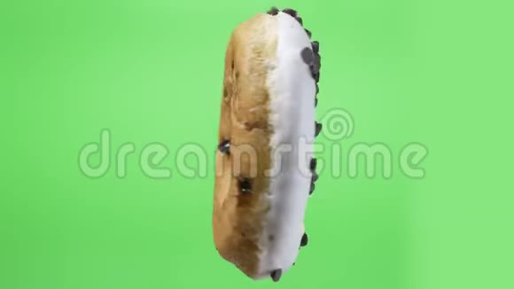 在绿色背景下旋转着的美味的白甜甜圈视频的预览图