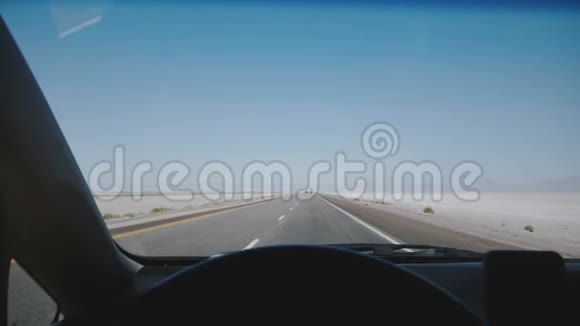 在犹他州邦纳维尔POV摄像机在汽车上沿着令人惊叹的白色盐湖沙漠道路向晴朗的蓝天地平线移动视频的预览图