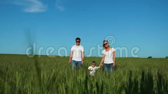一家人在田里散步一个孩子穿着白色T恤衫视频的预览图